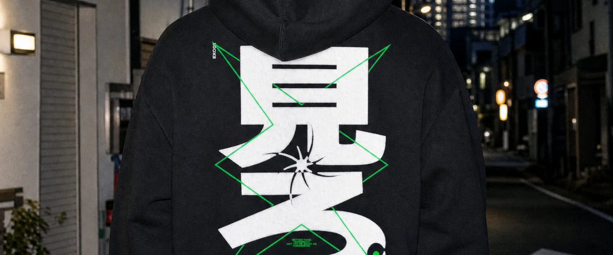 Hoodie EXODE BETTER porté, vu de dos en gros plan : grand kanji blanc 見ろ, de nuit en ville
